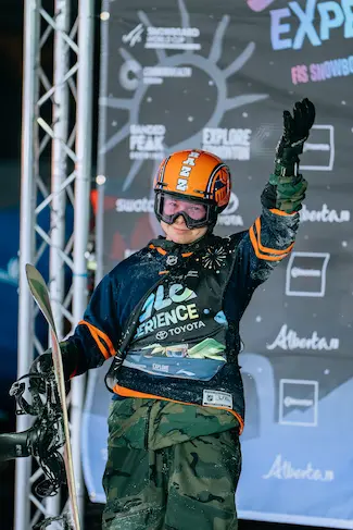 Snowboard posing with snowboard wearing an orange helmet